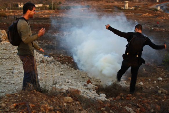 Israeli Activists Rush to Put Out a Tear Gas Canister. Photo: Joseph Dana  
