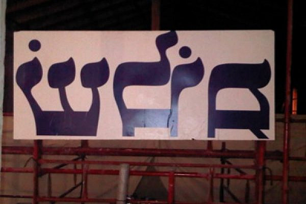 'Shalom' (peace) banner photographed from behind, so that it appears backward. (photo: Issa Boursheh)