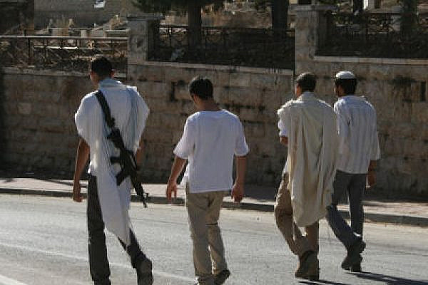 Settlers walking down Shuhada St. in Hebron (Credit: ISM Palestine, Flickr)