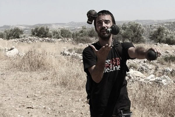 A man juggles with empty tear gas canisters. Bil'in, June 17 2011 (photo: Yossi Gurvitz)