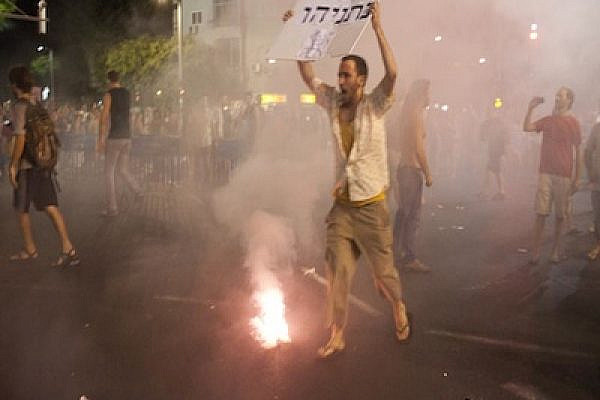 Protestor holding a sign equating Netanyahu to Mubarak and Assad (Photo:Oren Ziv)