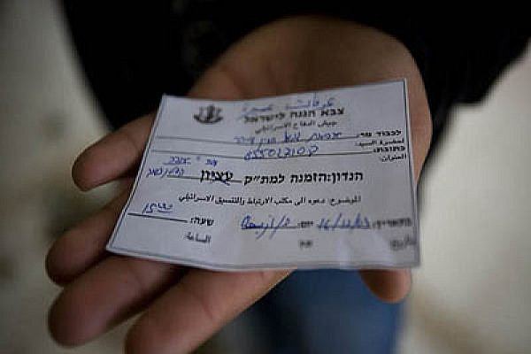A Palestinian displays an Israeli military court summons. Photo by Activestills.org
