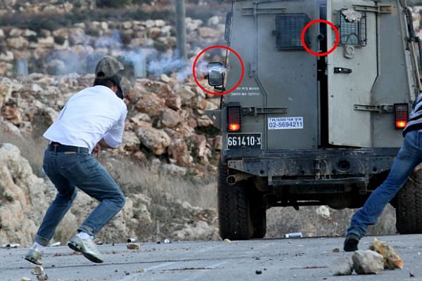 Mustafa Tamimi, a moment before he was injured. The weapon that shot him is circled in red, as is the tear gas canister that caused the fatal injury. Ibrahim Bornat can be seen in the edge of the frame. (photo: Haim Scwarczenberg)