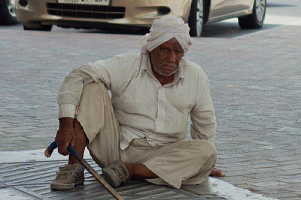 A Pakistani man sits on a street in Doha, Qatar in front of luxury vehicles, July 2011 (photo: PeregrinoWillReigh/fickrcc)