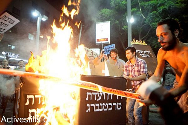 J14 protesters burn government reports which weren't implemented, Tel Aviv, July 7th 2012 (photo: activestills.org)