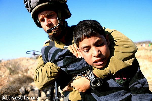 IDF soldier arresting Palestinian child (Activestills)