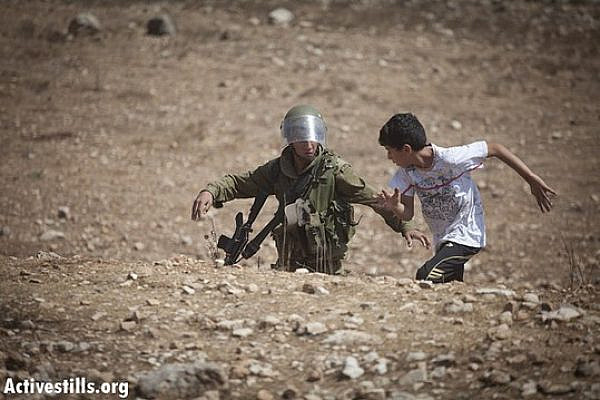 An Israeli soldier tries to arrest a Palestinian boy during the weekly demonstration against the occupation in the village of Nabi Saleh, September 21, 2012. (photo: Oren Ziv/ Activestills.org)