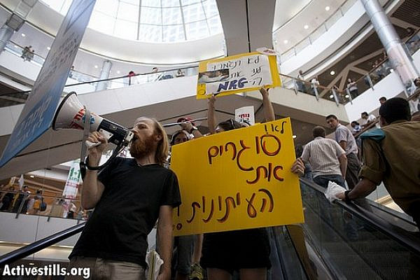 Employees of the Israeli newspaper Maariv protest against their dismissal inside Azriely commercial center on their way to the IDB offices, Tel Aviv, 20 September 2012. The daily has been sold by debt-strapped IDB Group to publisher Shlomo Ben-Tzvi who also owns the right-wing newspaper Makor Rishon and who agreed to take only 300-400 of Maariv's nearly 2,000 employees. (photo: Oren Ziv/ Activestills.org)