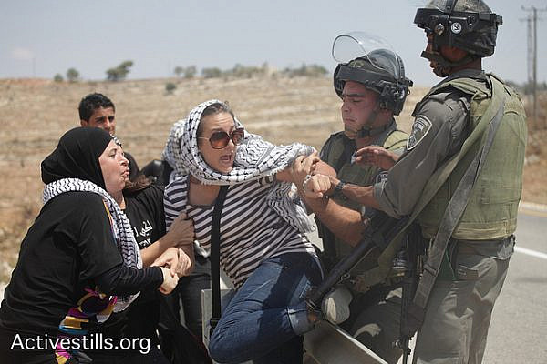 An Israeli solider attempts to arrest an activist during a protest in the West Bank village of Nabi Saleh, August 31, 2012. (photo by: Anne Paq/Activestills.org)