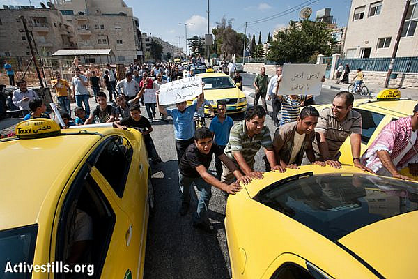 Palestinians push taxis along Hebron Road in the West Bank town of Bethlehem to protest the high cost of fuel and food, September 10, 2012. (photo: RRB/Activestills.org)