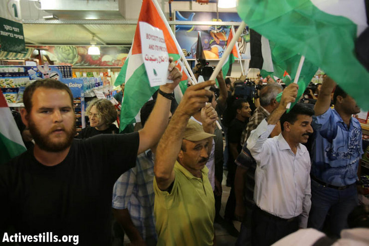 Palestinian protesters together with international and Israeli activists break into Rami Levi supermarket, located in the Sha'ar Binyamin settlement, to protest the Israeli occupation and to call for a boycott against Israelis settlements, October 24, 2012. (photo by: Yotam Ronen/Activestills.org)
