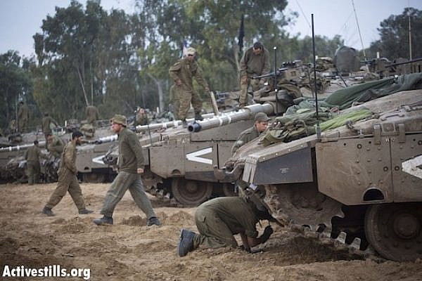 Israeli soldiers inspect their tanks on the Gaza border during Operation Pillar of Defense in 2012. (Photo by Activestills.org)
