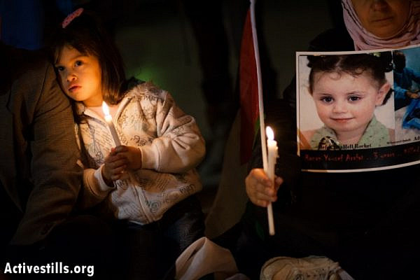 A girl holds a candle next to a photo of 3-year-old Ranan Yousef Arafat, who was killed by Israeli airstrikes in Gaza, as Palestinians gathered in Bethlehem's Manger Square to mourn the victims of Israeli military strikes and to call for an end to the escalation of violence, November 17, 2012 (photo: Ryan Rodrick Beiler/Activestills.org)