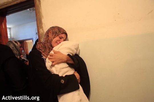 The mother Matar Abu Al-Atta, holding her newborn baby, born the night Matar was killed. (photo: Anne Paq / Activestills)