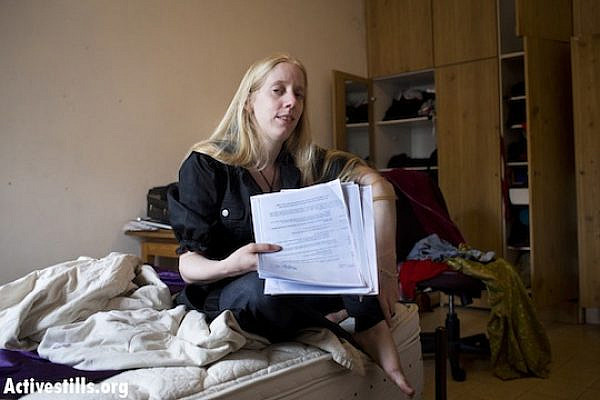 Anti-occupation activist Leehee Rothschild photographed with the closed military zone orders, delivered to her and 12 other activists in order to deter them from going to demonstrations against the separation wall. (photo: Activestills)