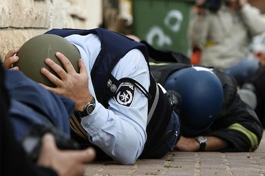 An Israeli police officer and reporters take cover during a rocket attack in the southern town of Sderot, Israel on December 30, 2008 (photo: Amir Farshad Ebrahim / CC BY-SA 2.0)