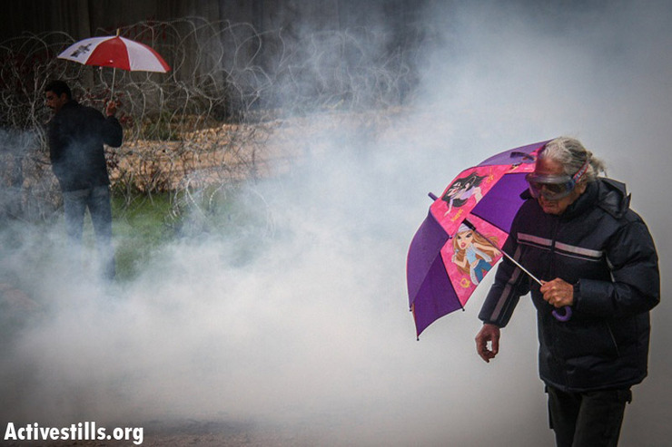 Demonstrators walk inside a cloud of tear gas shot by the Israeli army during the weekly protest against the wall and the occupation in the West Bank village of Bil'in, December 21, 2012. (photo by: Guest photographer Hamde Abu Rahma/ Activestills.org)