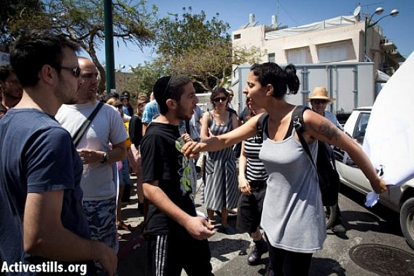 Arsonist-assister Haim Mula (center) confronting anti-racism activist (Oren Ziv / Activestills)