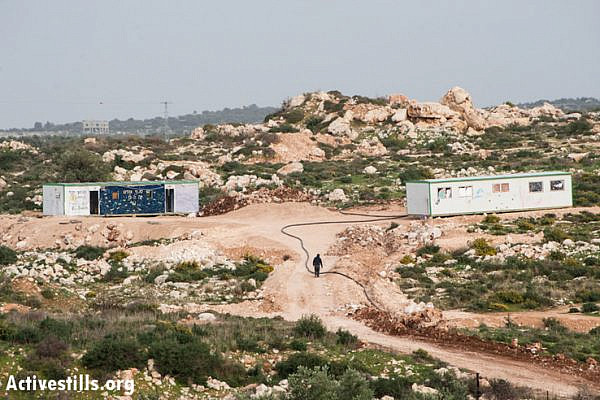 Two caravans form a new Israeli settler outpost on land belonging to the West Bank village of Jayyous, January 28, 2013. The structures were placed just one week prior, and are already being connected to water lines from the nearby settlement Zufin. The location was likely chosen to disrupt implementation of a 2009 Israeli court decision to re-route the separation barrier, returning a portion of Jayyous's land to the other side of the fence, including the area that the outpost now occupies. (Photo by: Ryan Rodrick Beiler/Activestills.org)