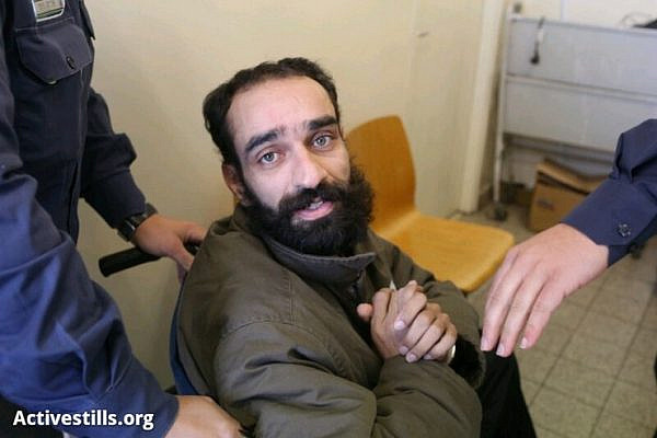 An Israeli prison guard escorts Samer Issawi, a Palestinian political prisoner, out of his court hearing in Jerusalem, January 16, 2013. Samer Issawi is on his 174th day of hunger strike, the court postponed the decision in his case to the 5th of February, 2013. (Photo by: Oren Ziv/Activestills.org)