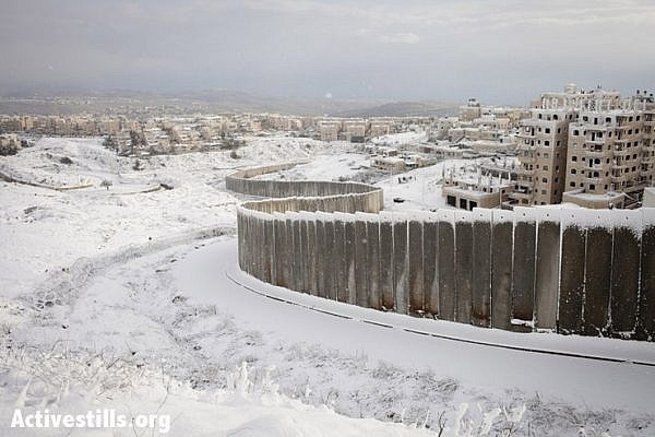 The Separation Wall between Shu'fat and Pisgat Zeev settlement, seen covered with snow after a winter storm, January 10, 2013. (Photo by: Shiraz Grinbaum/Activestills.org)