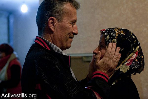 Released political prisoner Bassem Tamimi hugs his wife Neriman during his welcoming party at his home in Nabi Saleh, after spending three months in an Israeli jail, February 10, 2013.  Tamimi was arrested during an action calling for the boycott of settlement products inside an Israeli supermarket located in the West Bank settlement of Geva Binyamin. (Photo by: Keren Manor/ Activestills.org)