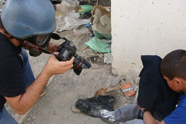 Photographer takes picture of a child choking on tear gas during the Nakba Day protest at Qalandia checkpoint in 2011 (photo: Mya Guarnieri)