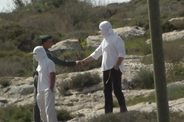 PHOTO: Why is a Border Policeman shaking hands with a masked settler?