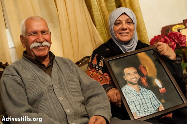 Tareq and Layla Issawi, the father and mother of Palestinian hunger striker Samer Issawi, smile with a portrait of their son in their home in the East Jerusalem neighborhood of Issawiya, two days after he signed an agreement with Israeli authorities to end his strike, April 24, 2013. Under the terms of the agreement reached late Monday, April 22, Issawi will be released to his hometown of Jerusalem after serving eight more months in jail, after 266 days of refusing food in protest against his rearrest by Israeli forces after being released in the Gilad Shalit prisoner exchange in October 2011. (Photo by: Ryan Rodrick Beiler/Activestills.org)