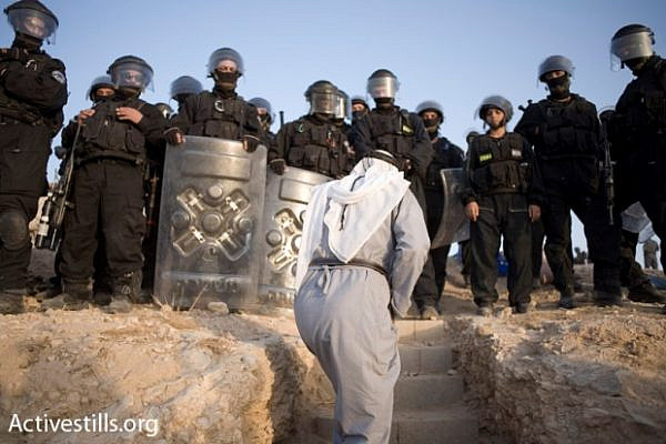 A resident of al-Araqib approaches Israeli police during one of the dozens of times authorities demolished the unrecognized village. (Activestills.org)