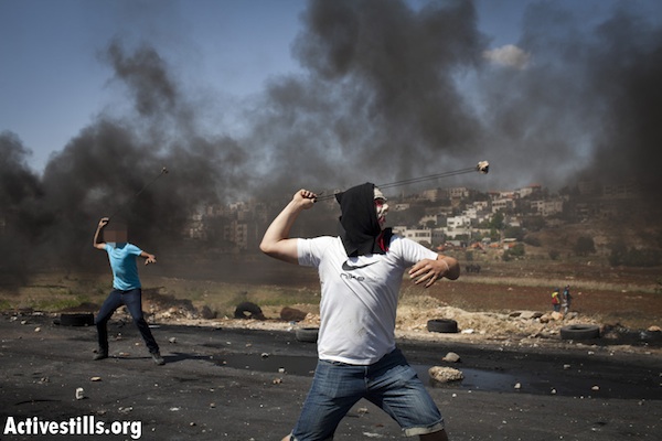Palestinian youth throw stones near Ofer Military Prison [illustrative], May 15, 2012 (Oren Ziv/Activestills.org)