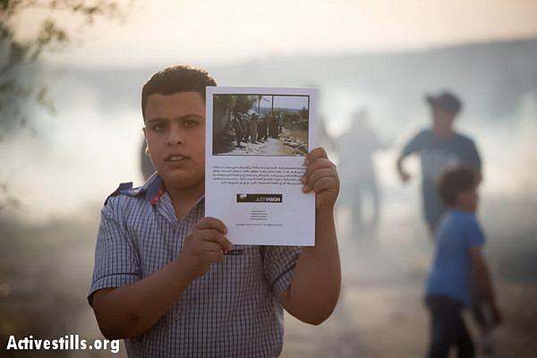A Palestinian youth in Budrus, with his new copy of the graphic novel, after the Israeli army interrupted the event, shooting tear gas into the village.