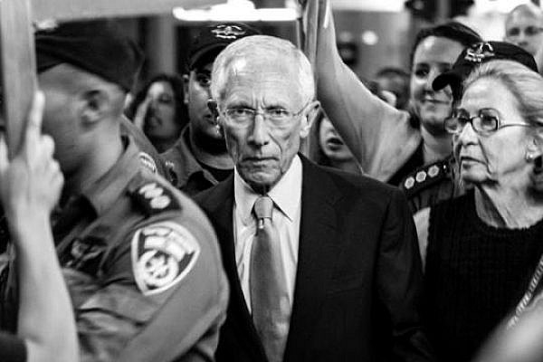 The Governor of the Bank of Israel and former Chief Economist World Bank Stanley Fischer surrounded by protesters as they walk out of a cultural event in Tel Aviv, May 25 2013 (photo: Ilai Ben Amar)