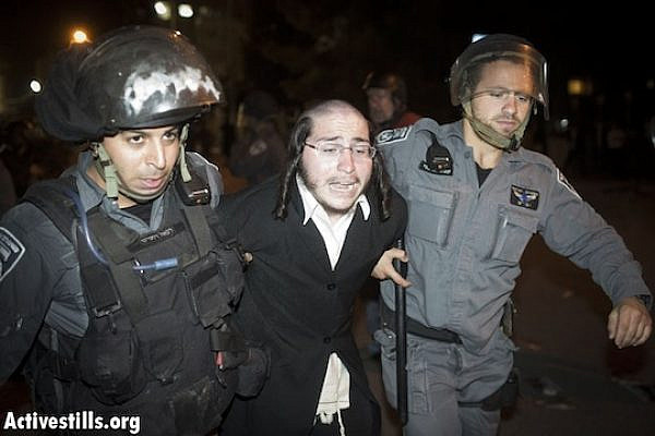 Police arrest an ultra-Orthodox man at a mass demonstration against plans to draft haredim into the Israeli army. (Oren Ziv/Activestills.org)