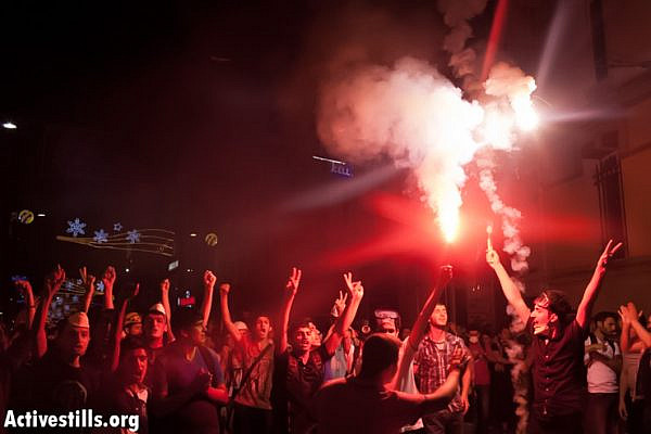 Protesters light a torch in Istiklal Street, near Taksim Square, during an anti-government demonstration, June 17, 2013. (Photo by: Oren Ziv/ Activestills.org)