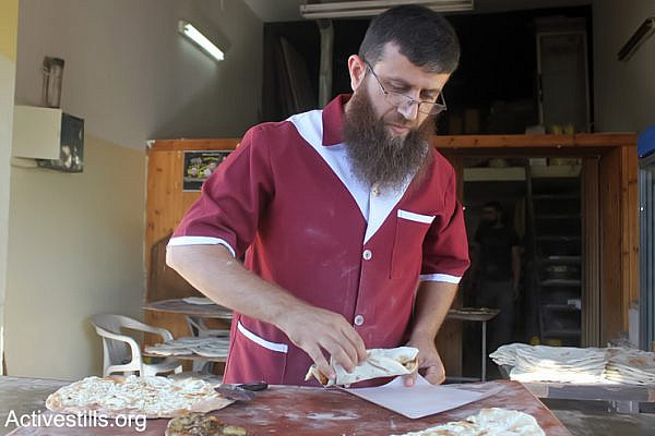 The Palestinian former prisoner Khader Adnan works at his bakery in the West Bank Village of Qabatiya near Jenin, June 21, 2013. Adnan is a former administrative detainee in Israeli jails. He was released on April 18, 2012, after being on hunger strike for 66 days. He inspired more than 1,200 Palestinian prisoners to start their own hunger strikes, For the Palestinians, he became the symbol of the hunger strike strategy. (Photo by: Ahmad Al-Bazz/ Activestills.org)