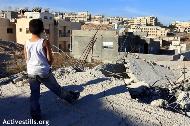 A child on a demolished home in East Jerusalem (Anne Paq / Activestills)