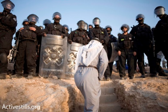 A Bedouin man confronts Israeli policemen during the destruction of the unrecognized village of Al-Araqib (photo: Activestills)