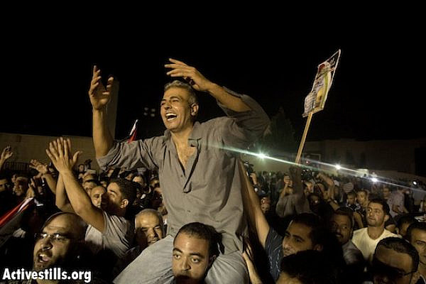 Palestinians carry on their shoulders.Palestinian prisoner Asmat Mansor, after he was freed from Israeli detention, Ramallah, August 14, 2013. (Oren Ziv/ Actviestills)