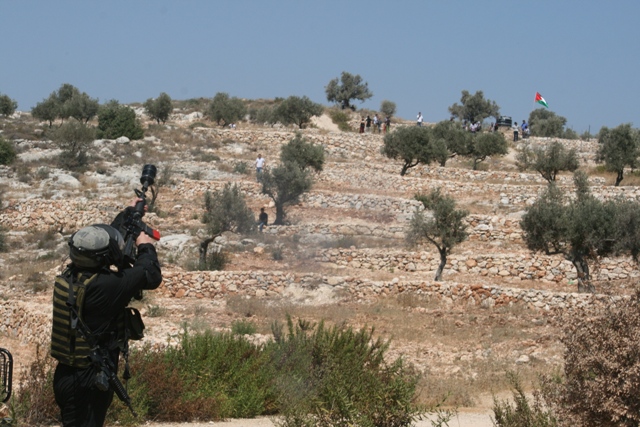 Soldiers firing tear gas and demonstrators (Haggai Matar)