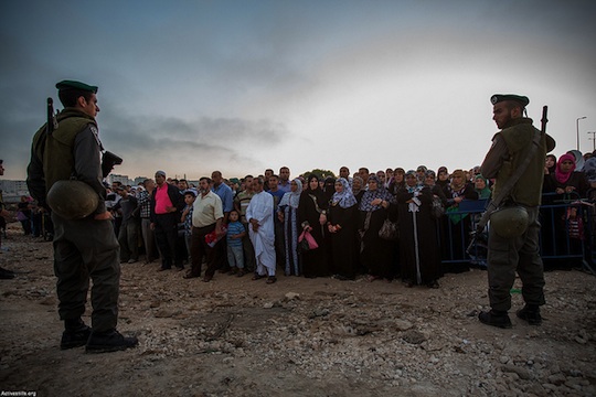 Israeli Border police officers corral Palestinians as they wait to cross from Qalandiya checkpoint outside Ramallah, West Bank, into Jerusalem, July 26, 2013. (Photo: Yotam Ronen/Activestills.org)