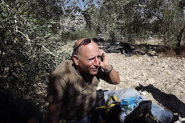 A man's face is bloodied after being attacked by Jewish extremists who descended from the direction of Yitzhar toward Palestinians and Israeli volunteers picking olives in Burin, October 20, 2013. (Photo: Munir Qadus / Yesh Din)