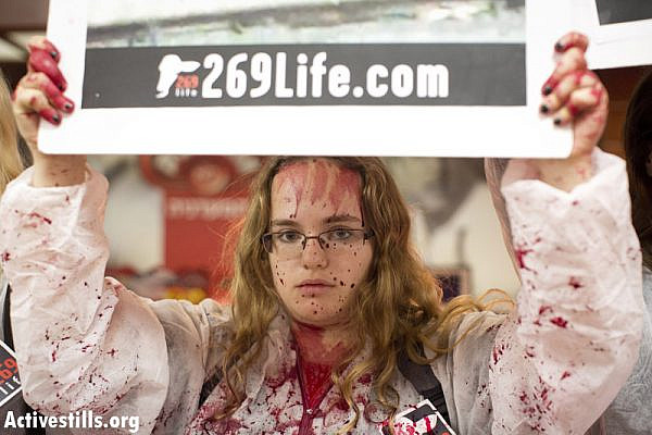 #269Life animal rights activists protest in a supermarket owned by the meat company Soglowek in the northern Israeli city of Nahariya, spraying red paint on the counters, November 20, 2013. Eleven activists were arrested. (Photo: Activestills.org)