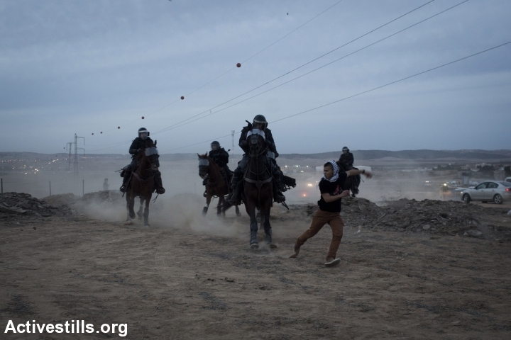 Mounted Israeli policemen chase a Bedouin youth during a protest against the Israeli government's Prawer Plan, on road 31 on November 30, 2013 near the town of Hura, Israel. 