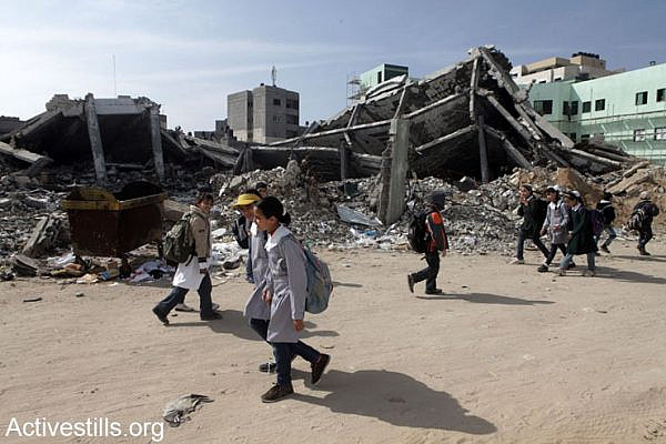 Palestinian children walking by demolished buildings of the Civil department of the Interior Ministry heavily bombed during last November's Israeli assault against the Gaza Strip, February 10, 2013.