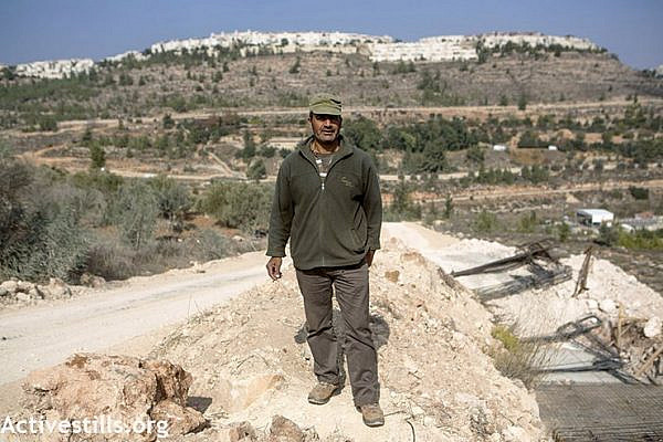 Hisham Abu Ali stands near road construction that threatens to uproot his olive trees in the village of Al Walaja. (photo: Anne Paq/Activestills.org)