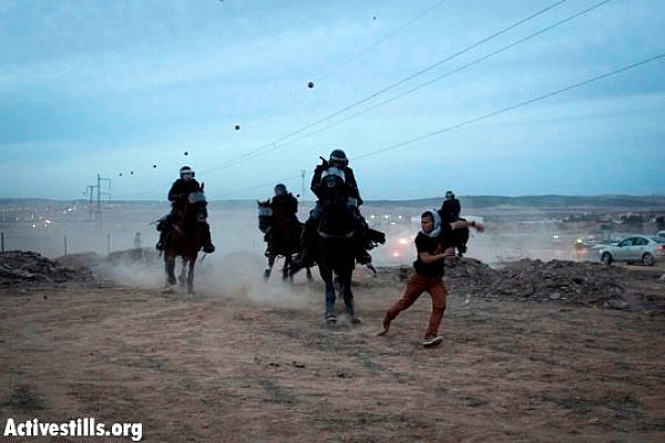 Mounted riot police chasing a demonstrator in the Negev Day of Rage, Hura, November 30, 2013 (Oren Ziv/Activestills.org)