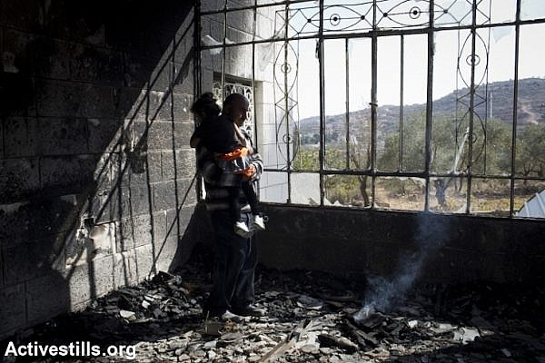 Khaled Abed a-Rahman Dar Khalil inspects the damage inside his home, which was torched by Jewish settlers, Sinjil, West Bank, November 14, 2013. Five children were treated for smoke inhalation. (Photo: Oren Ziv/Activestills.org)