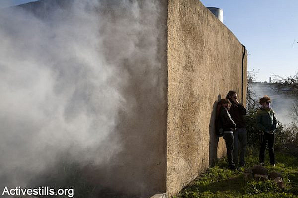 Israeli activists seek fresh air amid clouds of tear gas at the weekly demonstration in Nabi Saleh, January 6, 2012. (Photo: Keren Manor/Activestills.org)