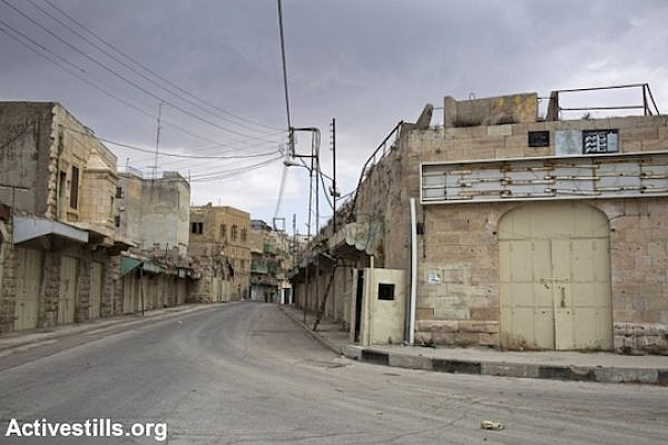 Shuhada Street in the Old City of Hebron, empty of all Palestinian vehicle and pedestrian traffic, November 13, 2013. Shuhada Street was the main commercial center of the city when it was first closed in 1994 to Palestinian traffic after the Ibrahimi Mosque Massacre, and later to pedestrians as the army shut down the entire commercial area. (Photo: Keren Manor/Activestills.org)